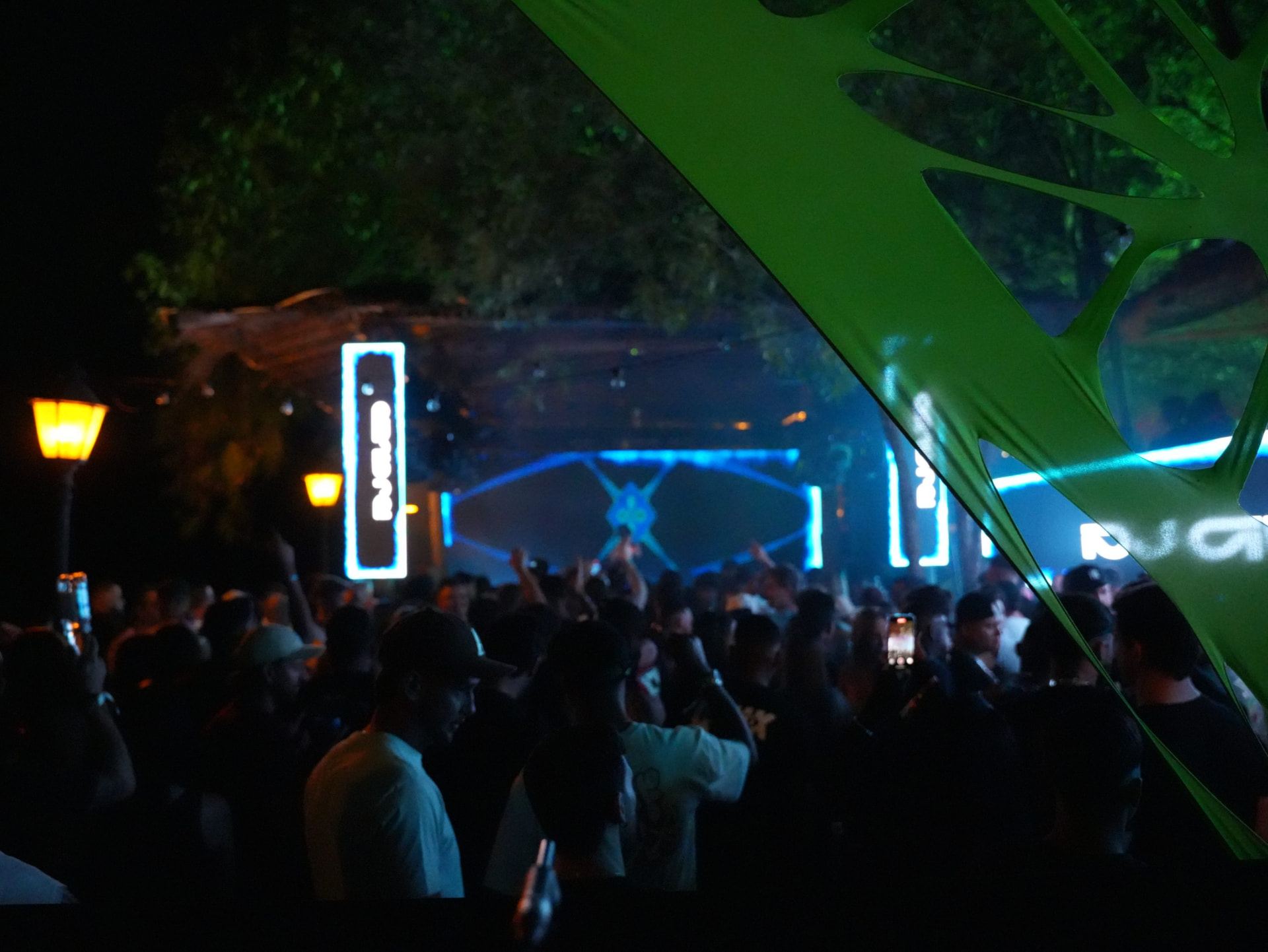 Público entre a vegetação diante do palco iluminado do Neverland